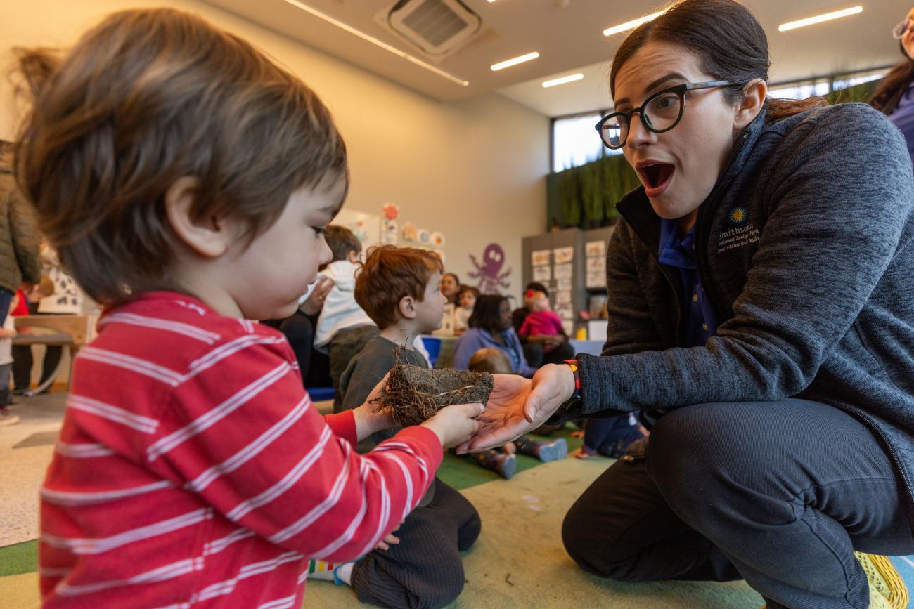 Educator explores a bird nest with young child